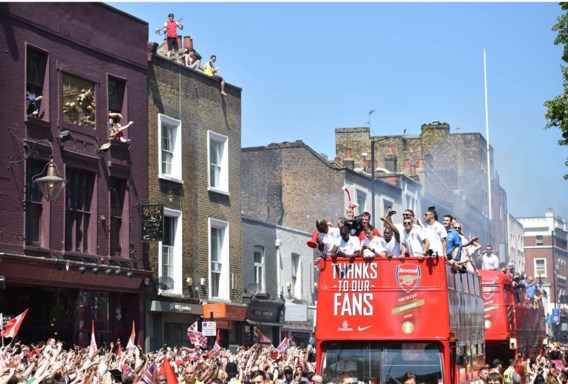 De spelers werden in een open bus van het oude stadion in Highbury naar het Emirates gereden.
