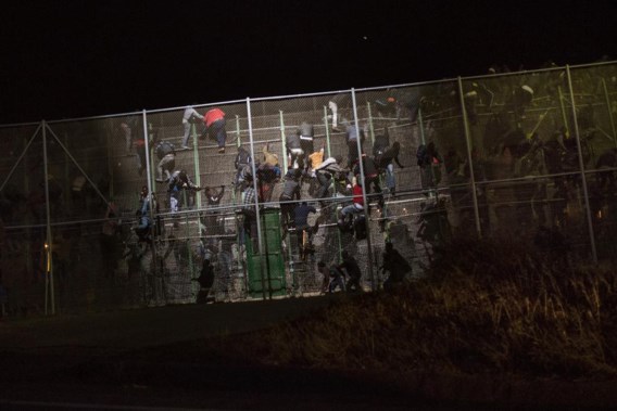 Aan de grens tussen Marokko en de Spaanse enclave Melilla proberen Afrikaanse migranten bij nacht over het hekken te klimmen.