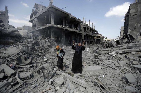 Twee Palestijnse vrouwen maken gebruik van het tijdelijke staakt-het-vuren in de Gaza-strook om naar buiten te komen. Wat ze aantreffen in het noordelijke district Beit Hanun is het puin van vernielde gebouwen.