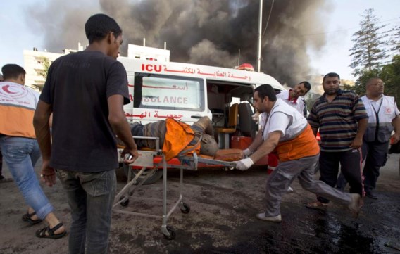 Hulpverleners voeren een Palestijn af die gistermiddag zwaargewond raakte bij een luchtaanval op een markt in het oosten van Gaza-­Stad.