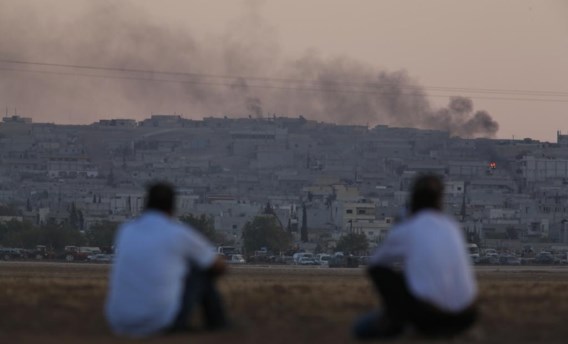 Vanuit Turkije kijken Koerden naar de Syrische grensstad Kobani, waar de Amerikanen de luchtaanvallen tegen IS opdrijven.