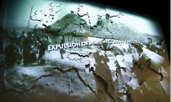 Op een scherm worden historische beelden over de pogroms geprojecteerd.