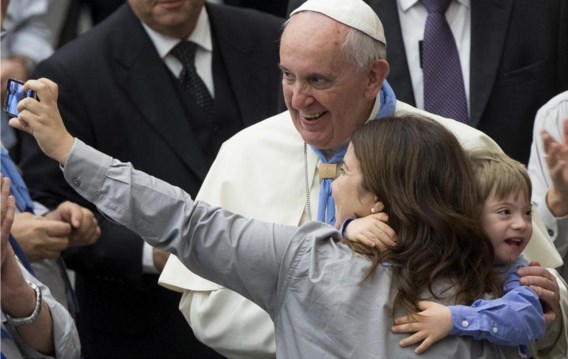 Een jongetje laat een selfie met zijn moeder en paus Franciscus aan zich voorbijgaan. 