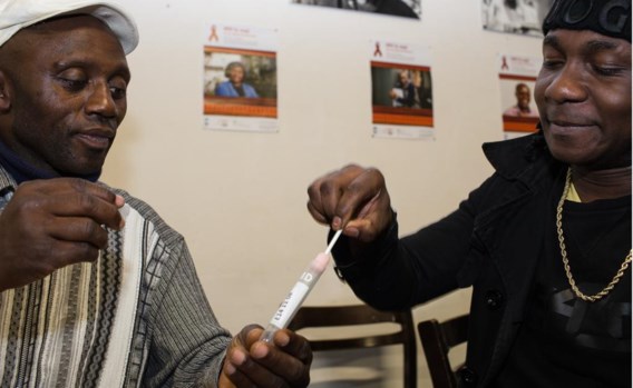 Twee Afrikaanse mannen nemen een speekselstaal af voor een hiv-test. ‘Je kan het maar beter weten, niet?’