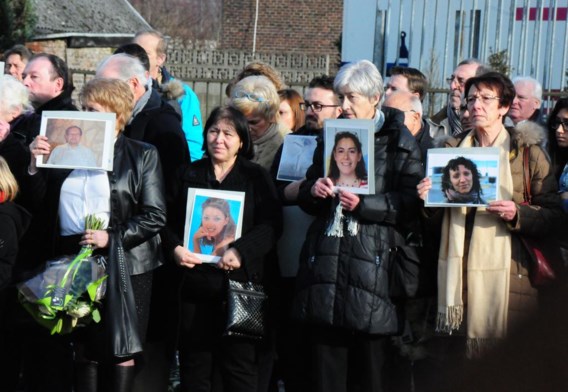 Familieleden hielden foto’s van de slachtoffers omhoog.