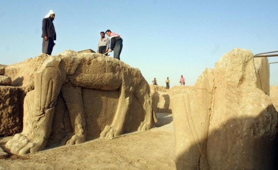 Op een archiefbeeld (foto 2001) is te zien hoe medewerkers op de site van Nimrud een beeld van een gevleugelde stier oppoetsen. 