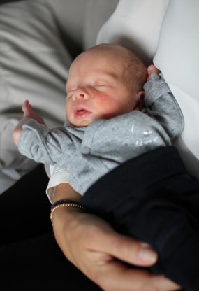 Vincent, het eerst kind gboren uit een getransplanteerde baarmoeder, op schoot bij zijn moeder.