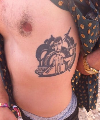 We spotten de tattoo van Jurgen Masure (28) uit Brussel ternauwernood. Hij zit half verstopt onder zijn hemd, maar de wind doet zijn werk. Het blote figuurtje op zijn ribben blijkt Paul van Ostaijen te zijn. ‘Mijn lievelingsdichter’, zegt Masure. ‘De tatoeage bestaat uit drie delen. Het getekende mannetje is een portret van Van Ostaijen door Paul Joostens. De dikke zwarte lijnen eromheen komen van houtsnedes uit zijn bundel Bezette stad. En ik heb er ook mijn favoriete verzen in verwerkt, de laatste regels uit Vers 6 uit de bundel Feesten van angst en pijn. Van Ostaijen was naar Berlijn gevlucht omdat hij in de Eerste Wereldoorlog had gecollaboreerd en was gebroken. Hij was zijn lief kwijt, had geen werk, geen geld, geen inspiratie, helemaal niets meer. En hij verlangde ernaar om opnieuw te kunnen beginnen. Niet dat ik me vereenzelvig met wat hij schreef, het is gewoon een krachtige apotheose van een mooi gedicht.’ Het was Jurgens eerste tattoo. ‘Vier en een half uur heeft mijn vriend Younes zitten kerven op m’n ribben. Vreselijk.’ Zo ondraaglijk kan het niet geweest zijn: op zijn borst prijkt ondertussen ook een vers van Lucebert, ‘Alles van waarde is weerloos’. Ewald DupontIn deze rubriek gaan we op zoek naar een opvallende tattoo en het verhaal erachter.