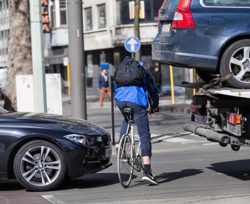 Een fietser wurmt zich in het Antwerpse door het autoverkeer.