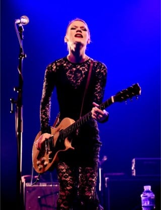Whitley reageert zich af op haar gitaar.
