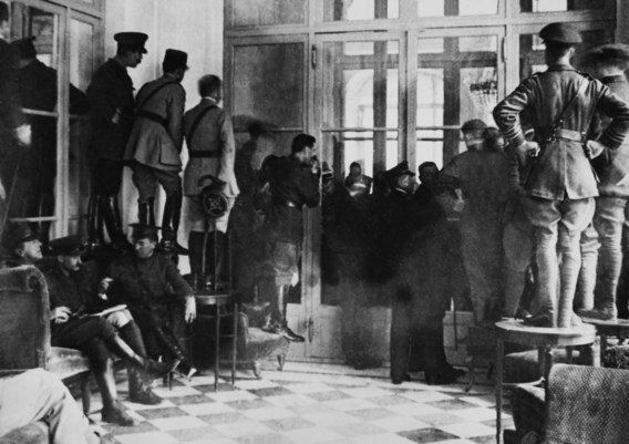 Nieuwsgierigen proberen een glimp op te vangen van de onderhandelingen tijdens de Conferentie van Versailles in 1919.