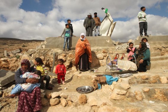 Leden van een Palestijnse familie op het puin van hun door Israël gesloopte woning in Masafar Yatta.