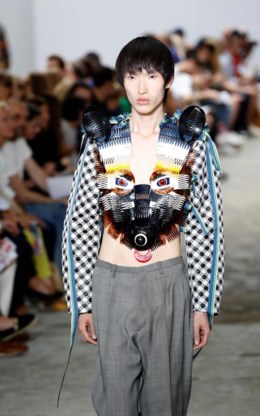 ‘Why is a raven like a writing-desk?’ luidt de titel van de zomercollectie 2017 van Walter Van Beirendonck. Het bizarre raadsel komt uit Alice in Wonderland. De rups stelt Alice vragen die ze niet kan beantwoorden. ‘Ik heb dit onderwerp gekozen omdat we in een tijd leven met veel vragen en bitter weinig antwoorden’, zegt Van Beirendonck. ‘Ik heb gewerkt rond schoonheid in al haar onvolmaaktheid. Zoals pakken met gaten die met linten afgeboord zijn. Ik had op een markt in Londen prachtige vintage linten gevonden.’ Blikvangers in de collectie waren de blazers met kleurrijke vogels en de mouwloze hesjes in de vorm van etnische maskers, gemaakt van oude kammen, schoentrekkers en andere objecten van de rommelmarkt.Het resultaat zijn intrigerende creaties tussen kunst, juwelen en mode.