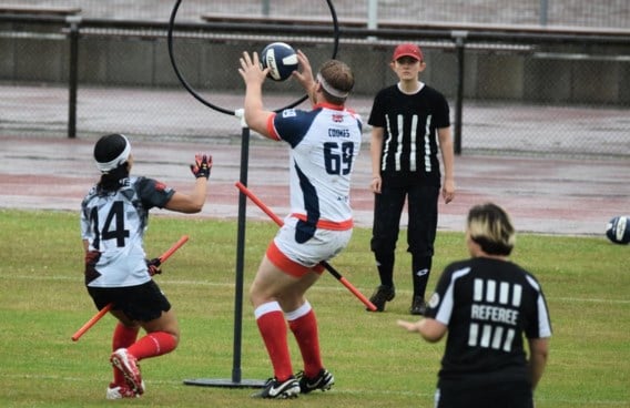 Spelers klemmen tussen hun benen een pvc-buis die een bezem moet voorstellen. Scoren doen ze door een bal door de hoepels te gooien. En o ja: ze moeten ook een sok met daarin een tennisbal proberen te vangen. Zes scheidsrechters leiden dat alles in goede banen.