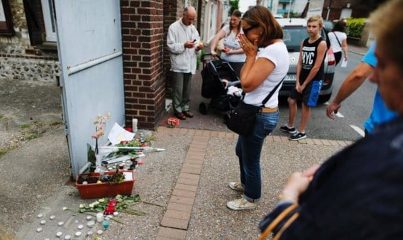 Een vrouw houdt enkele momenten van bezinning in acht voor het huis van de vermoorde priester Jacques Hamel.