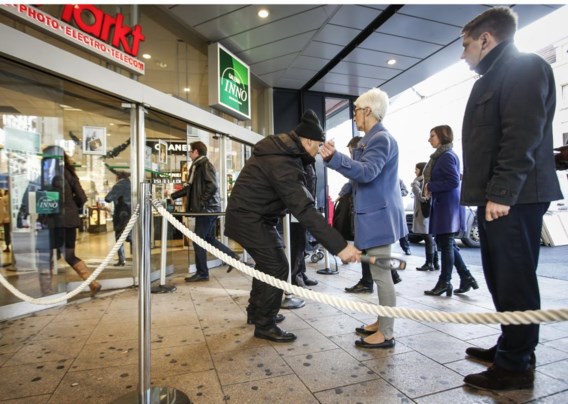Man controleert vrouw, aan de Inno in Brussel.