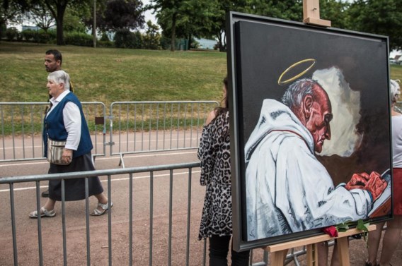 Zuster Danielle, zelf even gijzelares van de terroristen, wandelt voorbij het portret van de vermoorde priester Jacques Hamel.