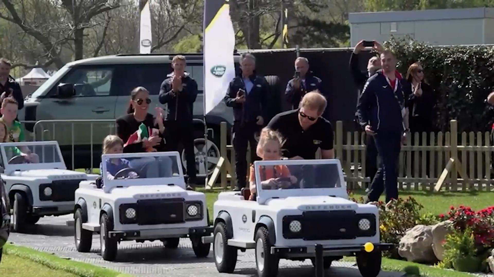 Prince Harry and Meghan Markle take a ride in mini Land Rovers with children at the wheel