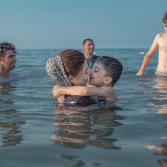 Een familie aan de Kaspische Zee. Er zijn enkele plekken waar vrouwen vrij kunnen zwemmen, daarbuiten moeten ze de hidjab dragen.