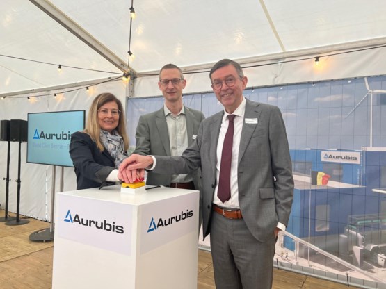 De Olense burgemeester Seppe Bouquillon wordt geflankeerd door Els Lievens en Dirk Vandenberghe van Aurubis.